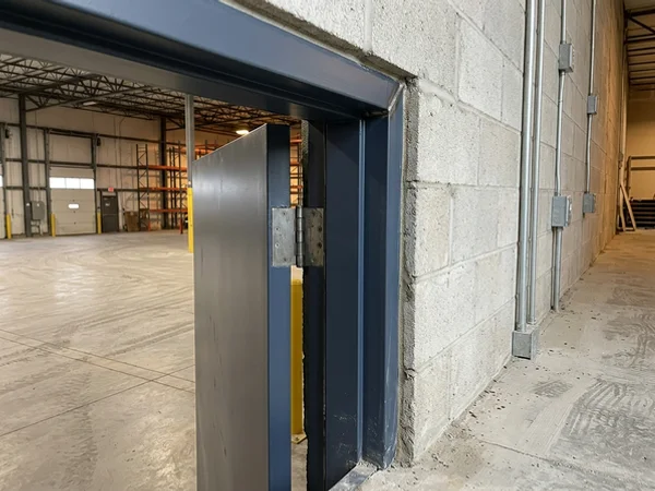 Welded hollow metal frame anchored and grouted into a block wall